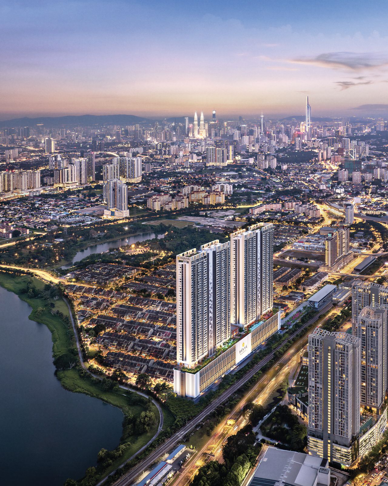 黄昏时分的 Taman Wahyu 鸟瞰：涵雅双塔立于铁道旁，前景是湖泊，远方是吉隆坡天际线